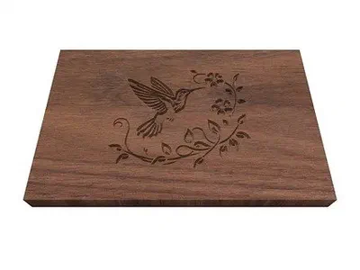 A hummingbird engraved on a walnut box lid.