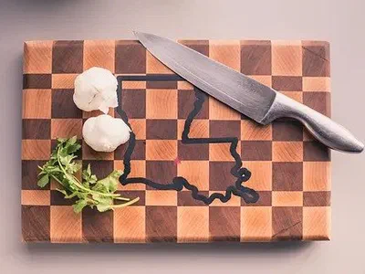 An end grain checkerboard cutting board with a state outline filled in dark epoxy.