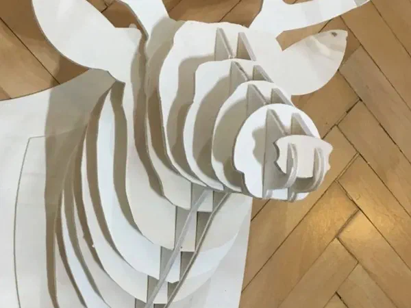 A layered plywood deer head with antlers mounted on a wall.