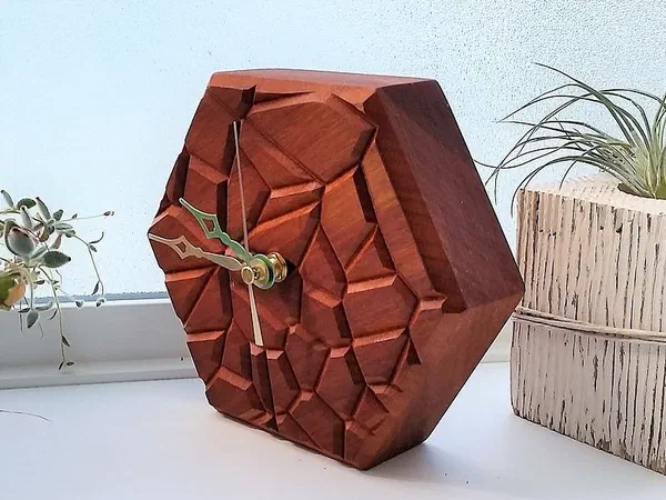 A faceted red wooden clock with an irregular cell pattern across its face.